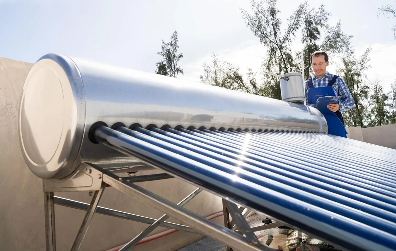 Kỹ thuật viên đang kiểm tra lắp đặt máy nước nóng năng lượng mặt trời tại Dĩ An